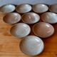 Set of 10 turned stoneware plates, pyritised and glazed, wabi-sabi brutalist.