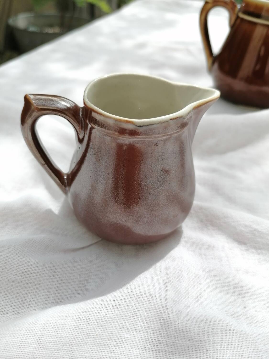 Brown ceramic teapot and milk jugs