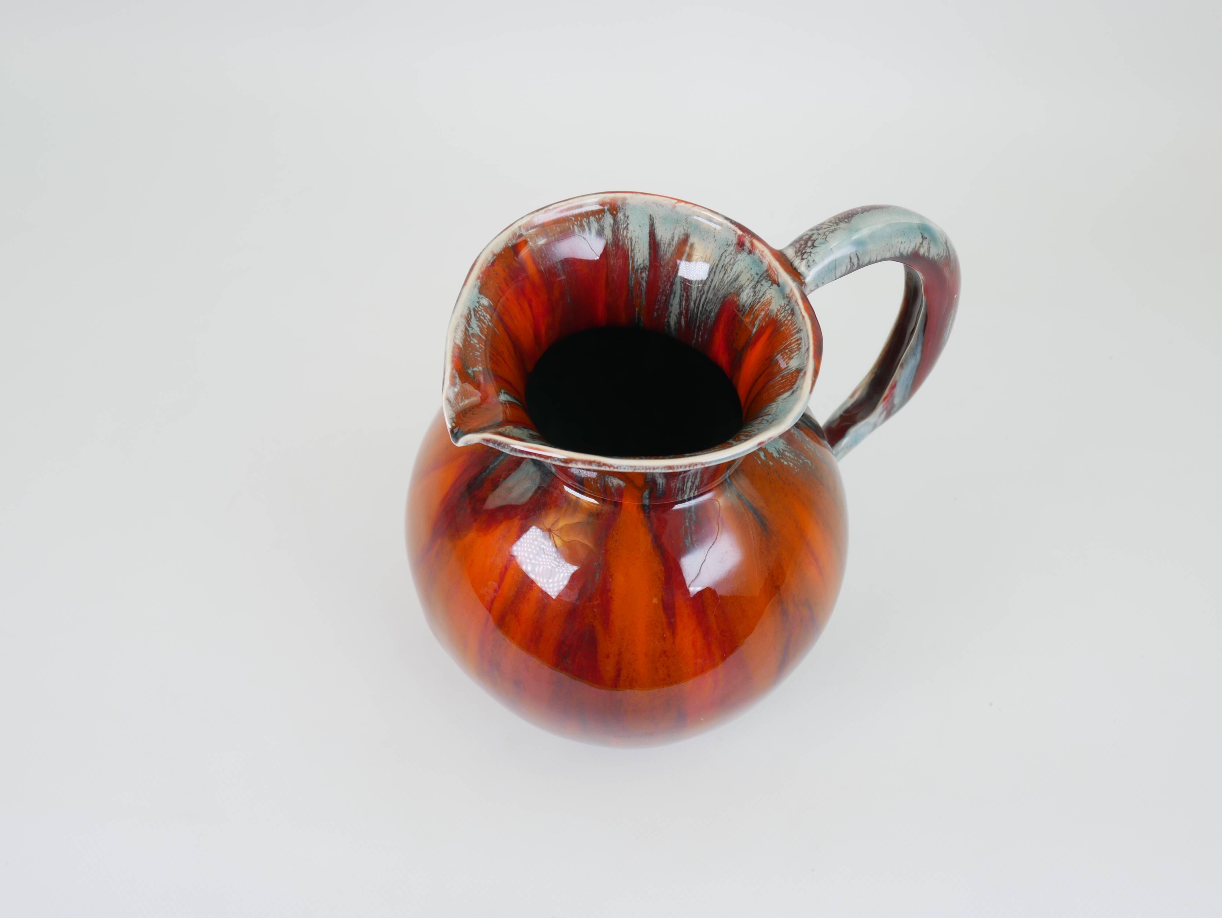 Pichet en céramique émaillée rouge et bleu signé Delène