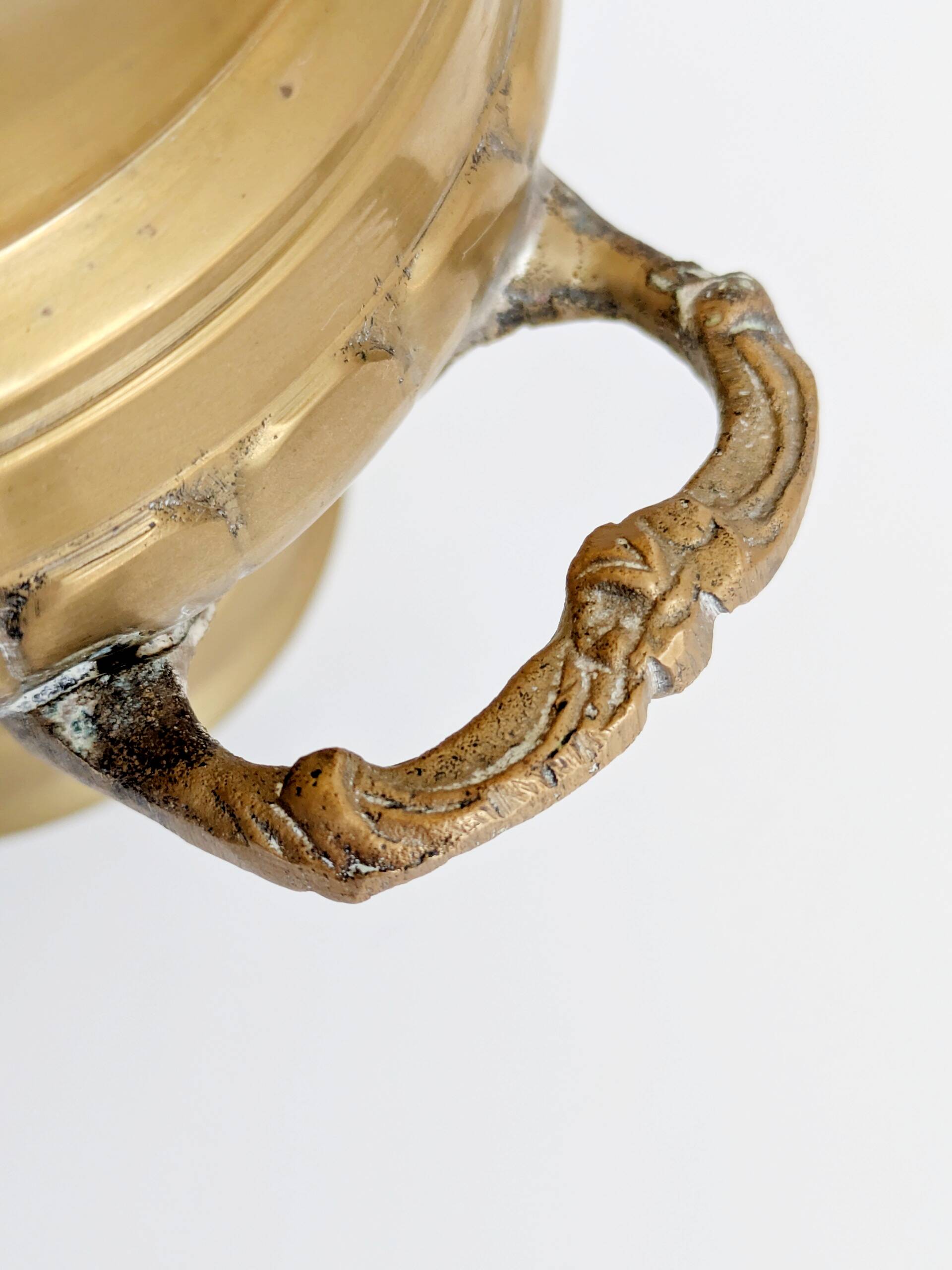 Vintage brass cache-pot on a stand with handles, classic decor.