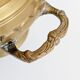 Vintage brass cache-pot on a stand with handles, classic decor.