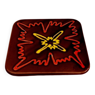 Vintage ceramic trivet with a 70s pattern.