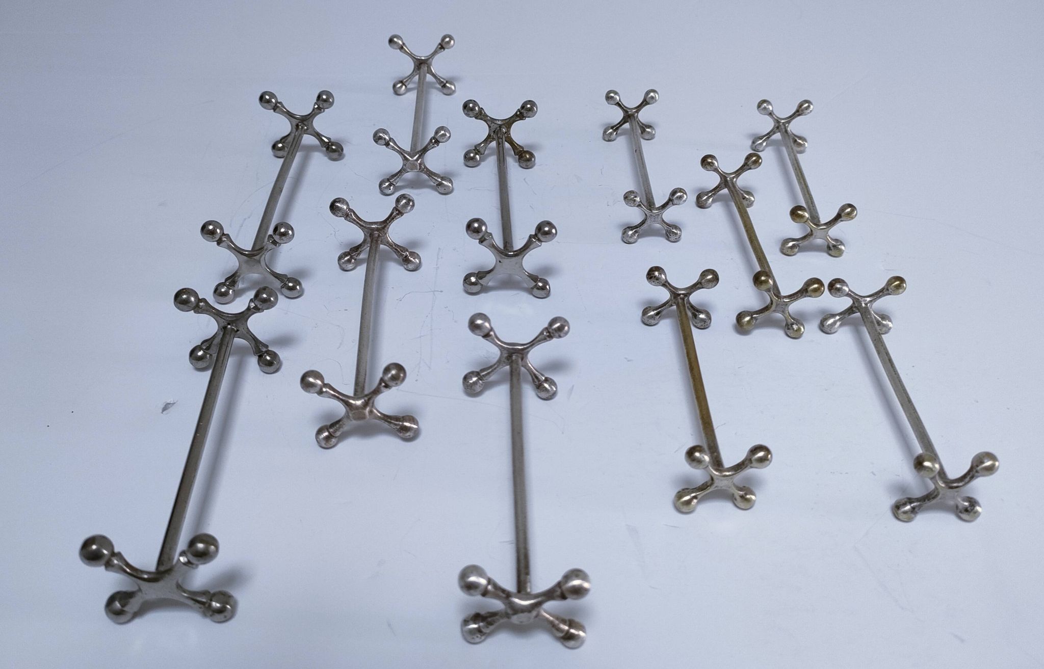 Eleven 70s design metal "crosshair" knife holders