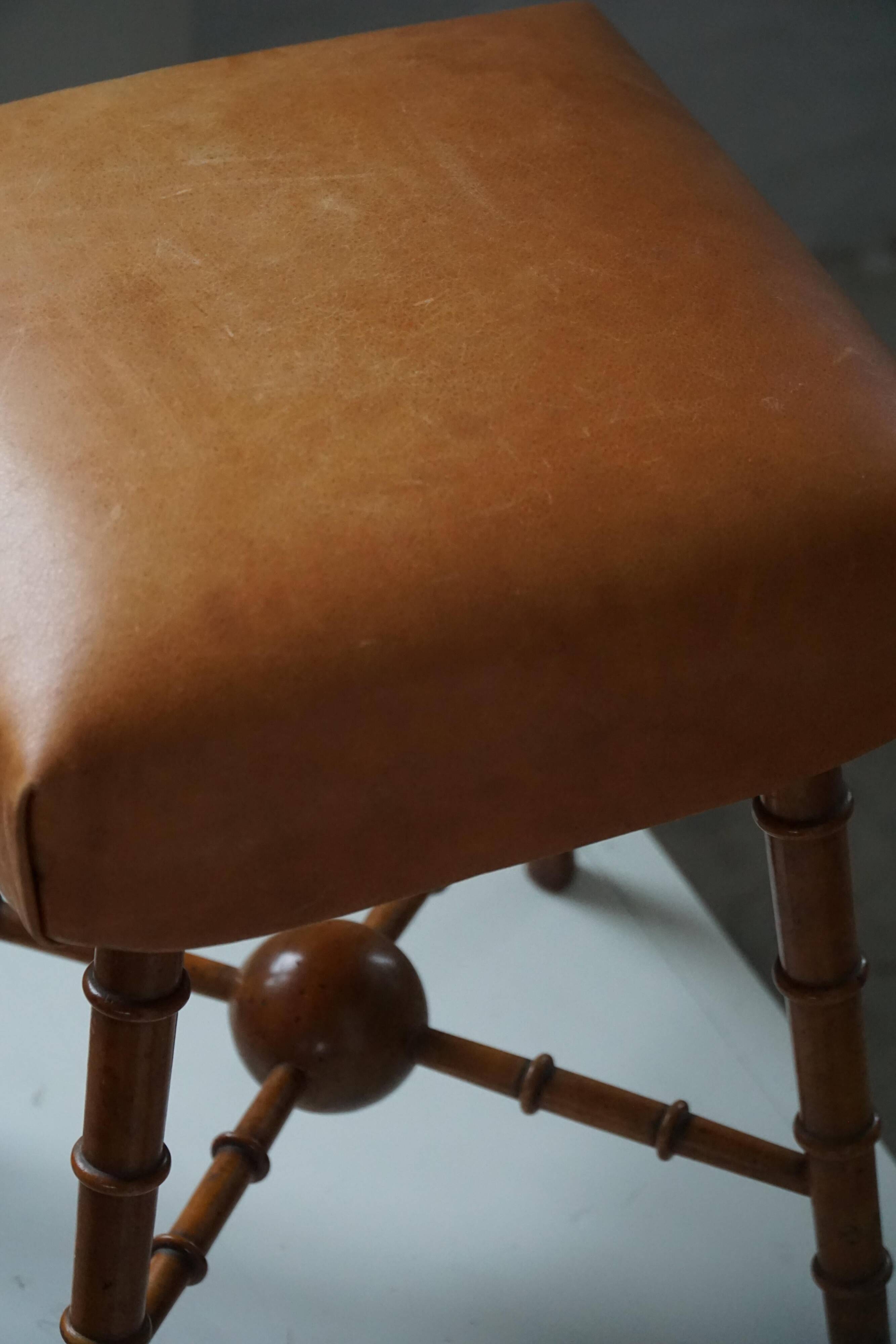 Turned wooden stool with leather seat, mid-20th century, Danish modern.