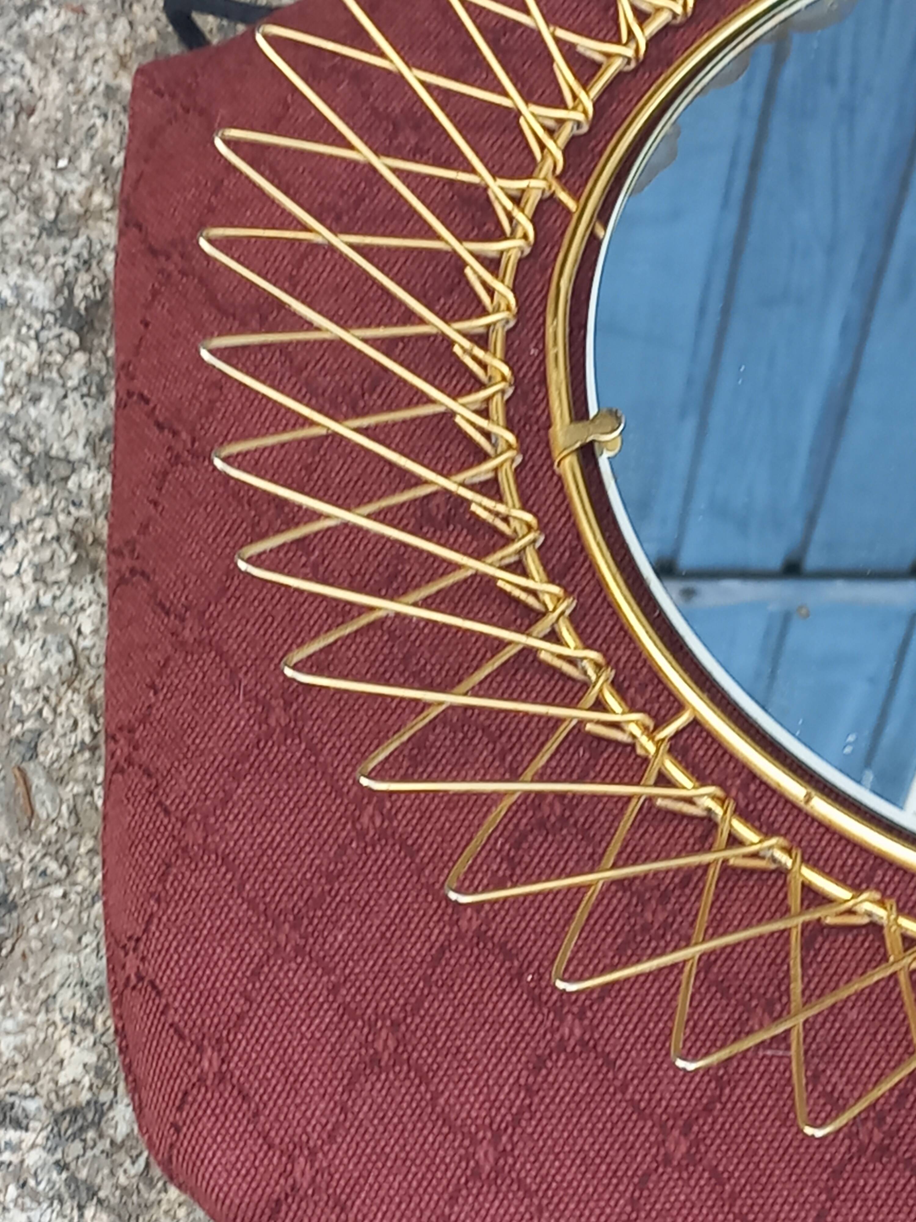 Vintage 1950s sun mirror in gold metal.