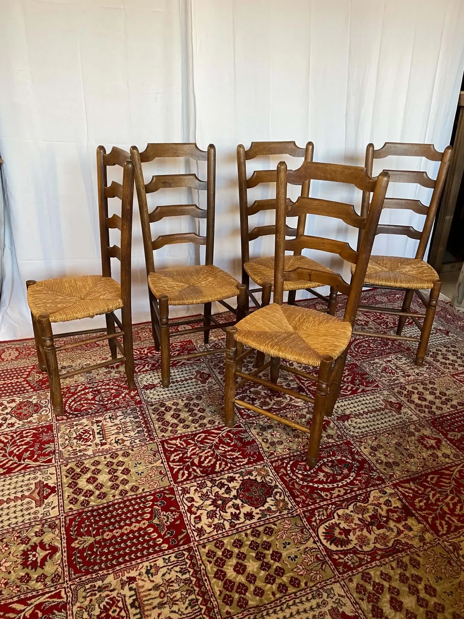 Set of 5 antique solid oak chairs with straw seats.