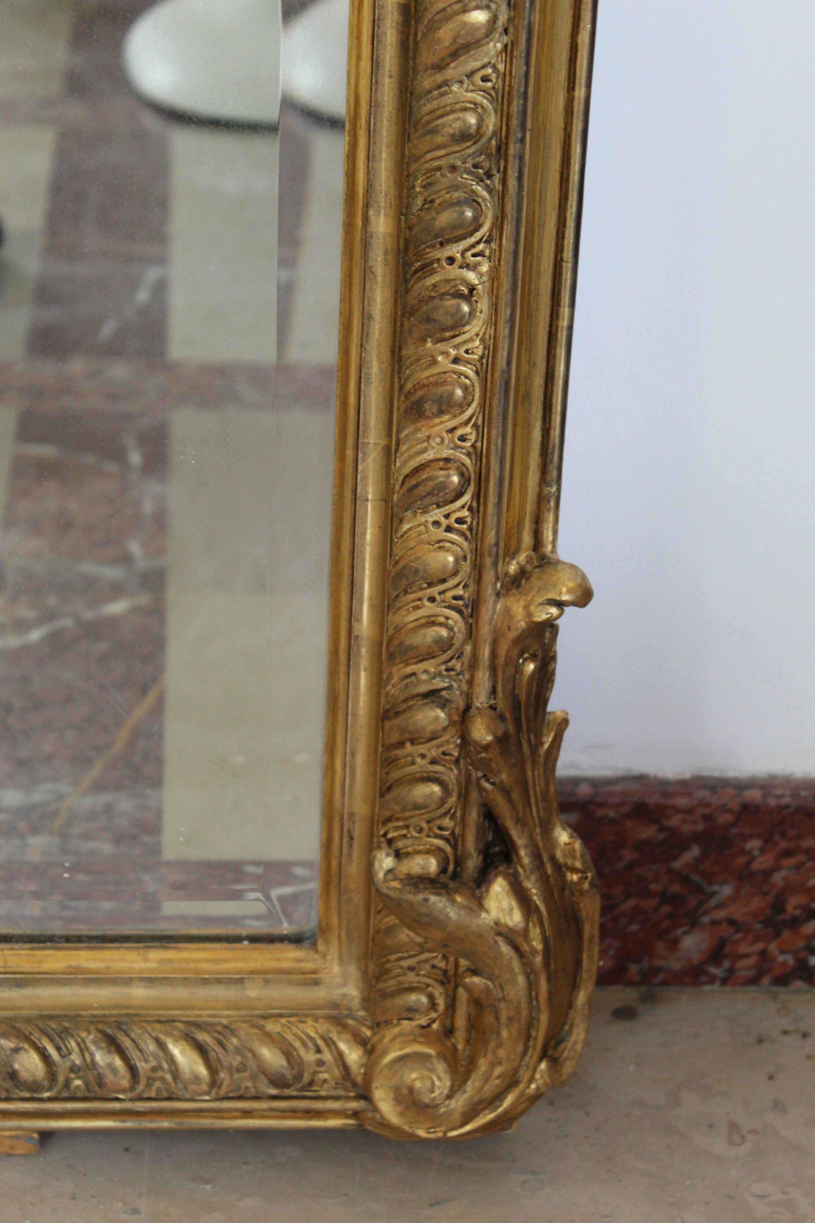 Large 19th-century wooden and gilt-studded mirror decorated with a cornucopia motif.