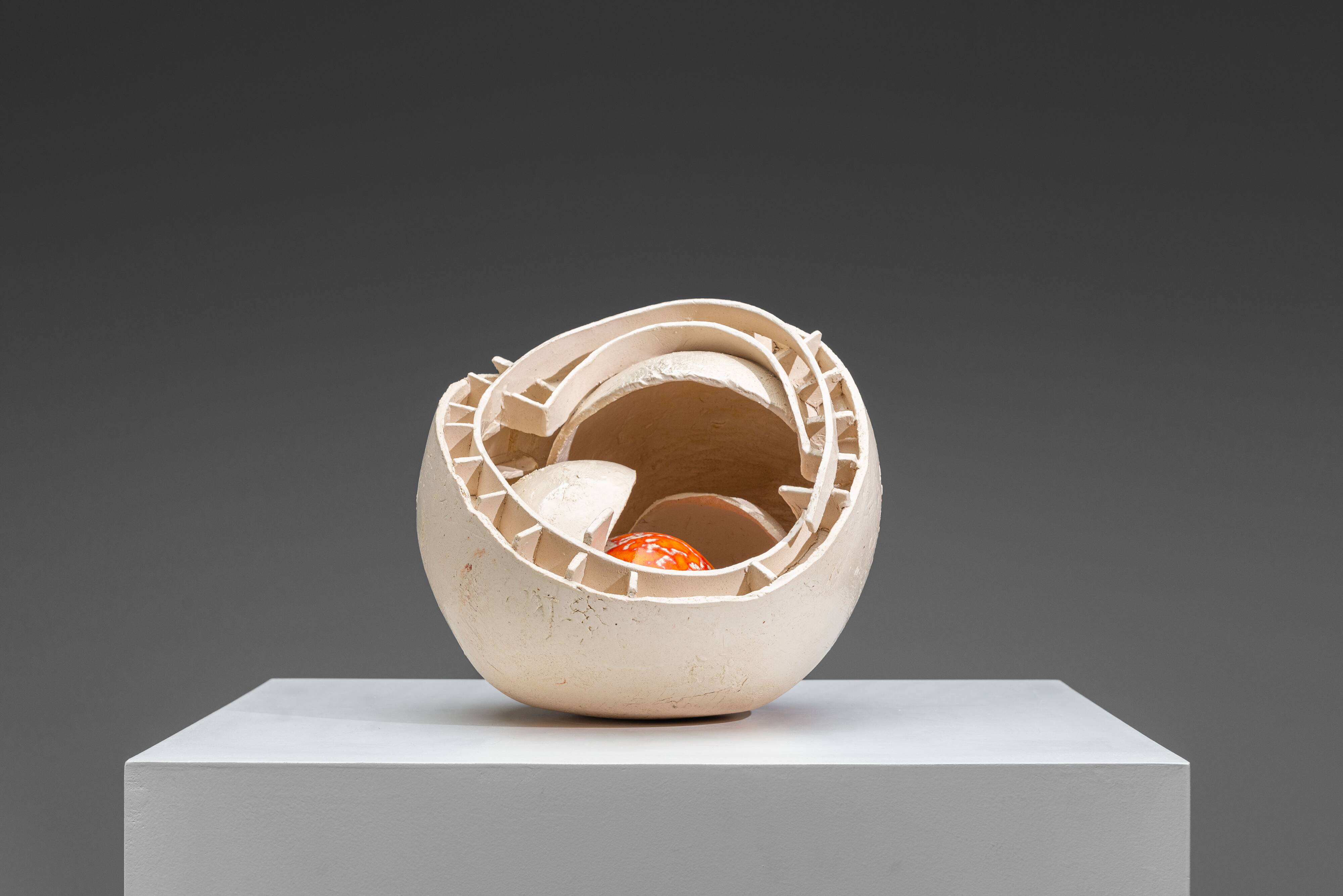 Sculpture en céramique abstraite avec un noyau orange.