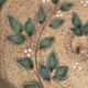 Decorative glazed terracotta plate with olive leaf pattern.