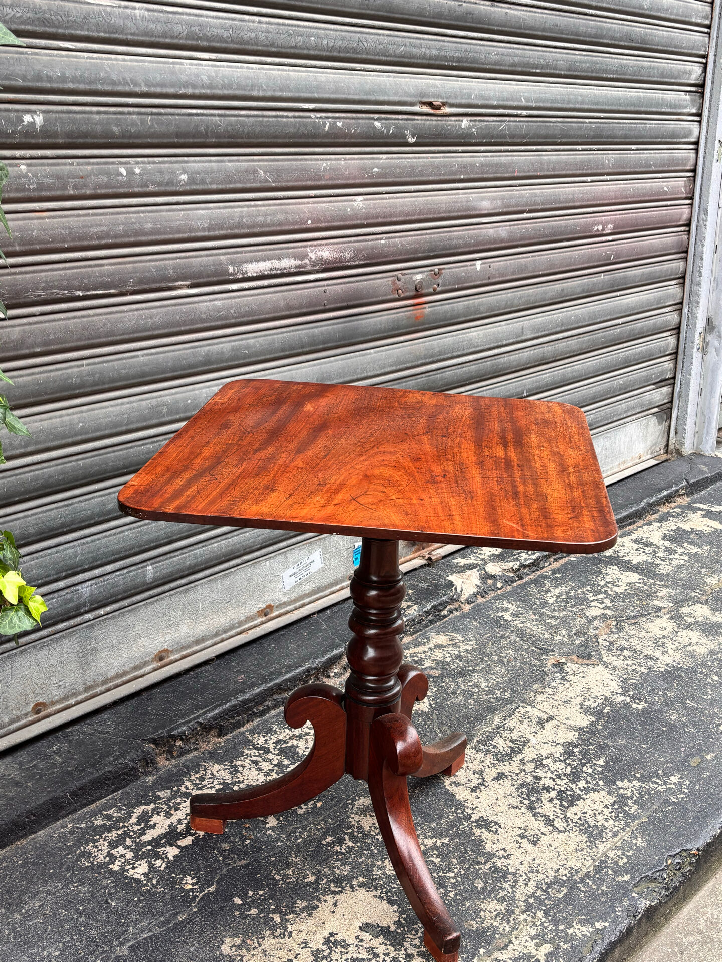 19th-century solid mahogany table with a tilting top and brass mechanism.