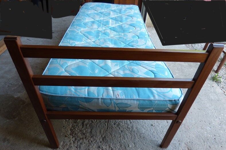 Single bed with wooden headboard and footboard and metal box spring