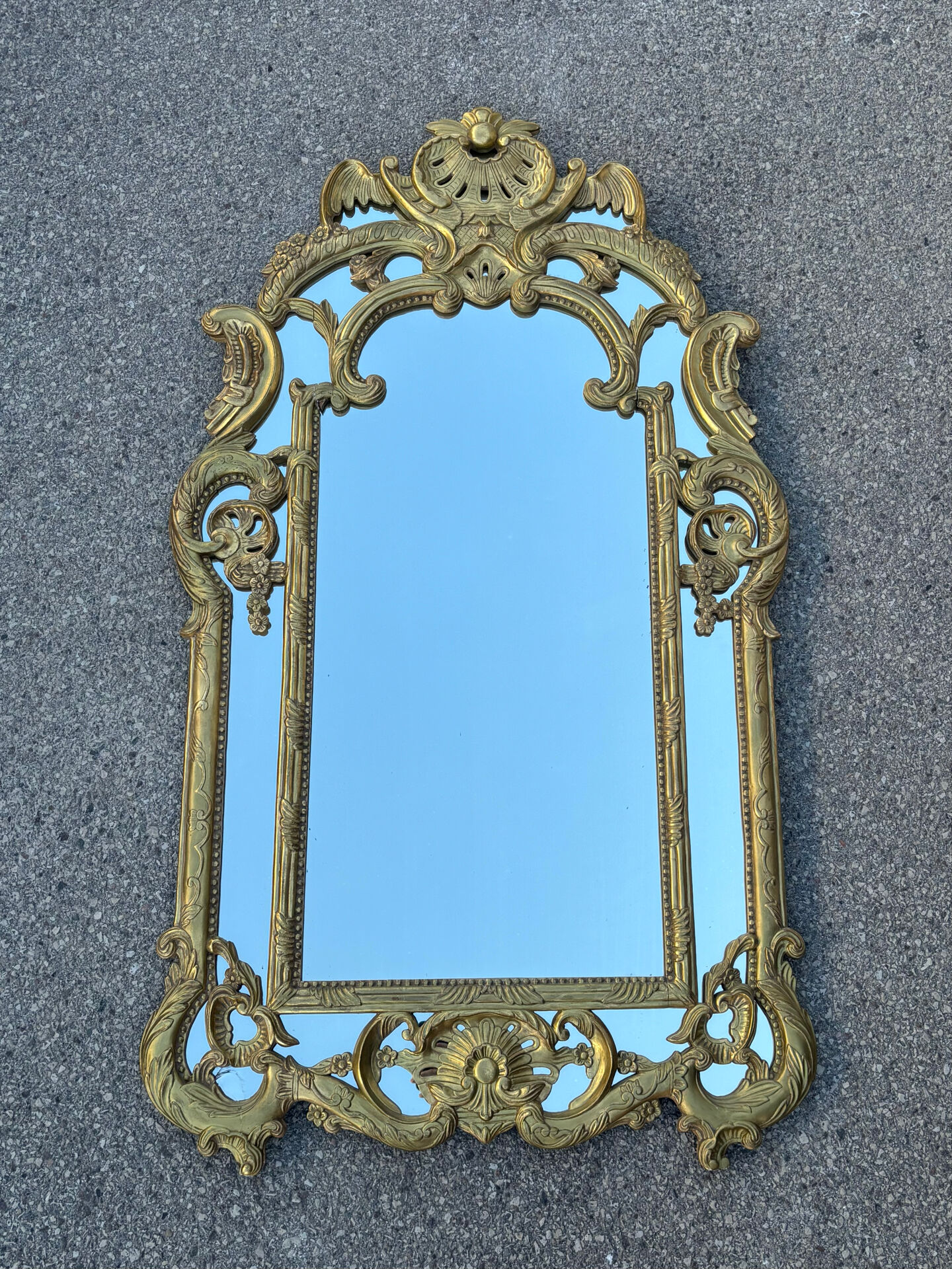 Large mirror with carved and gilded wooden frame, in Regency style.