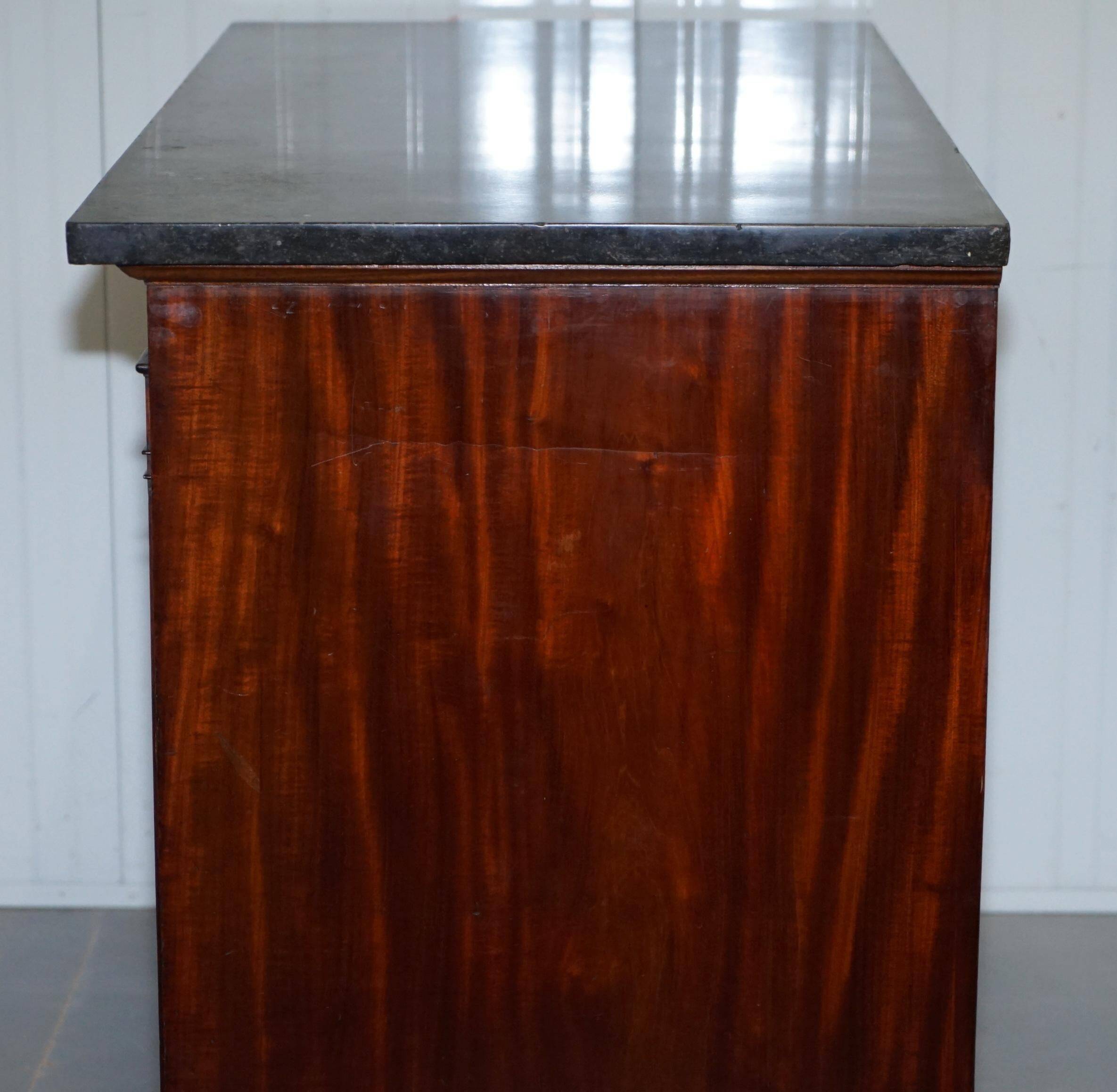 19th-century Empire commode with a marble top and lion paw feet.