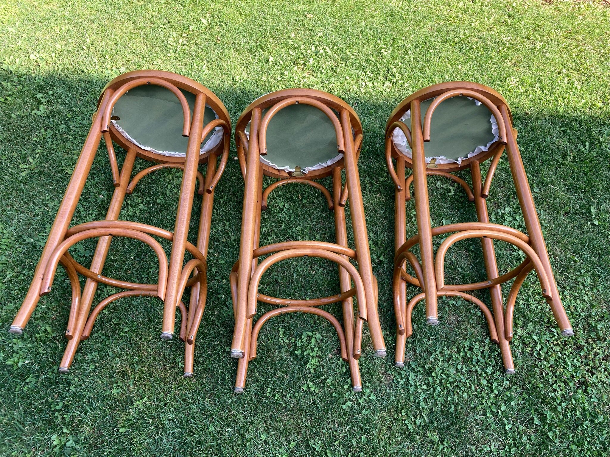 3 bar stools made of curved wood and fabric seat