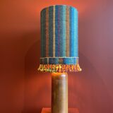 "Stoneware Bottle Lamp" with a multicoloured blue lampshade handwoven in India.