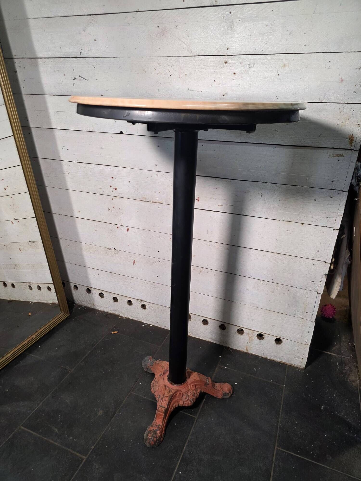 Bistro standing table with marble top and cast iron base.
