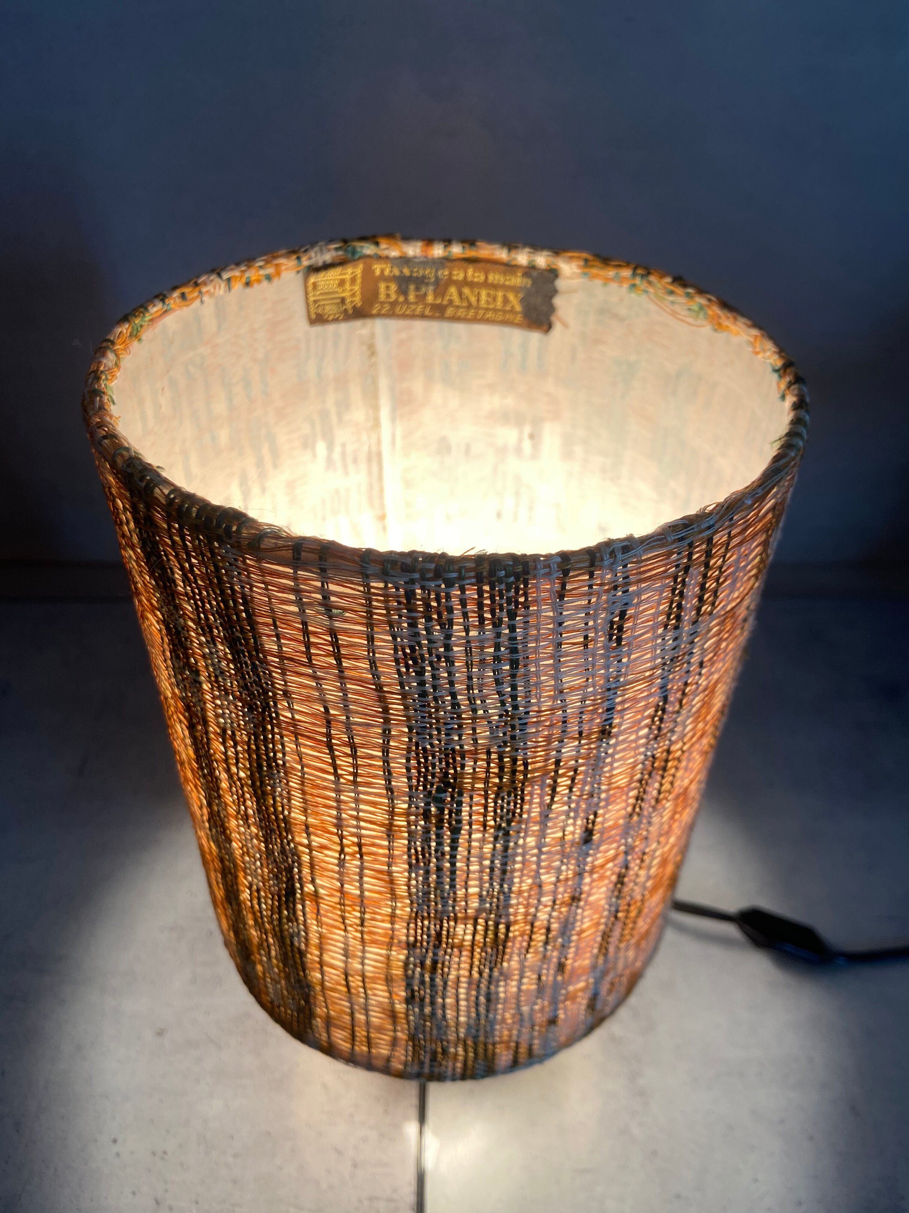 Small modernist table lamp with hand-woven shade.