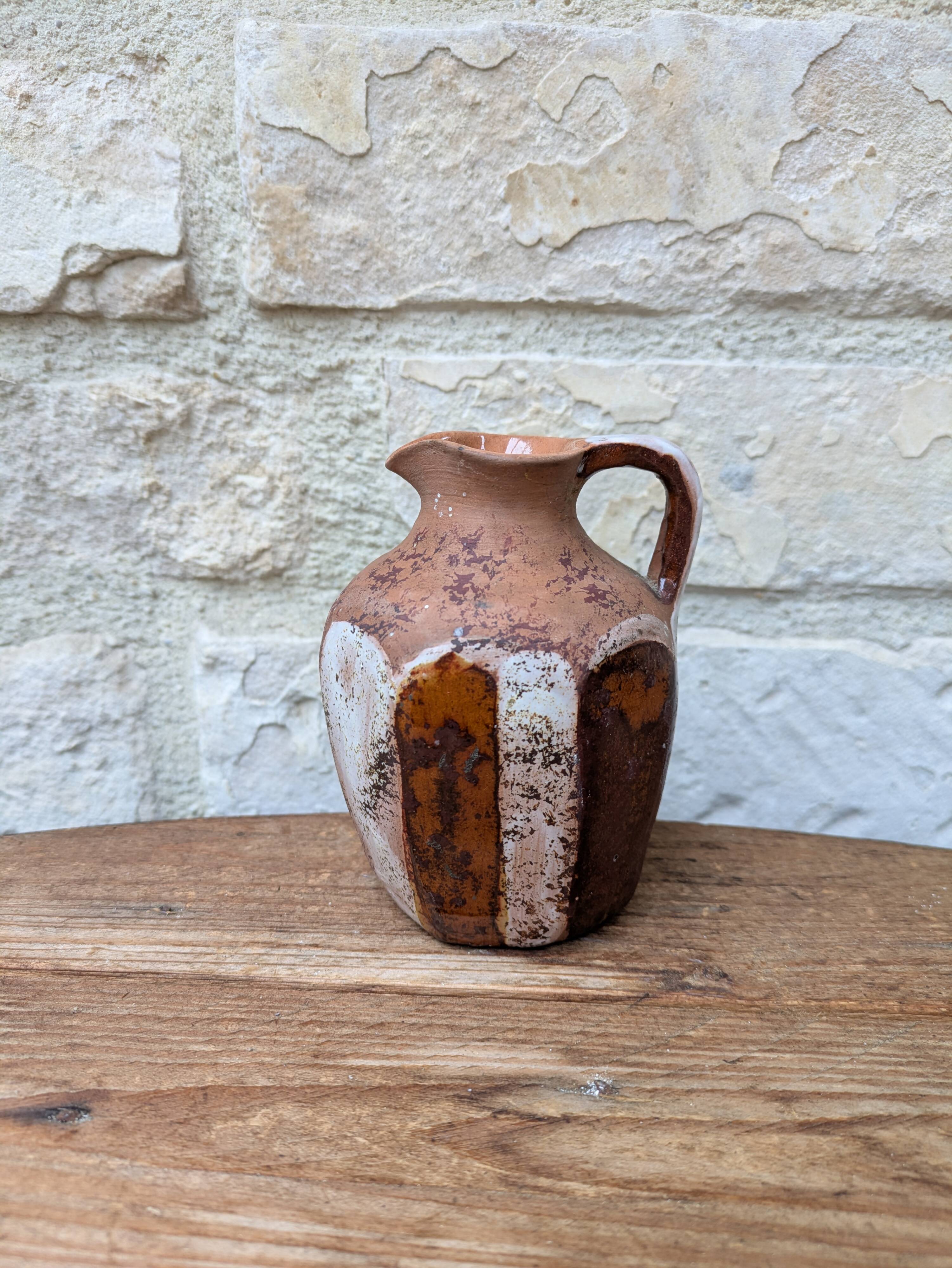 Old small pitcher in glazed terracotta