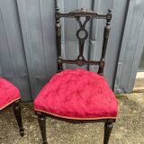 Pair of black lacquered chairs with purple tufted upholstery.