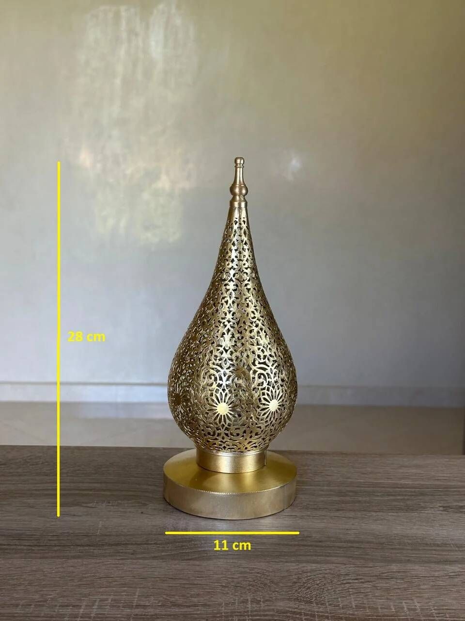 Handmade brass table lamp with a perforated drop-shaped shade.