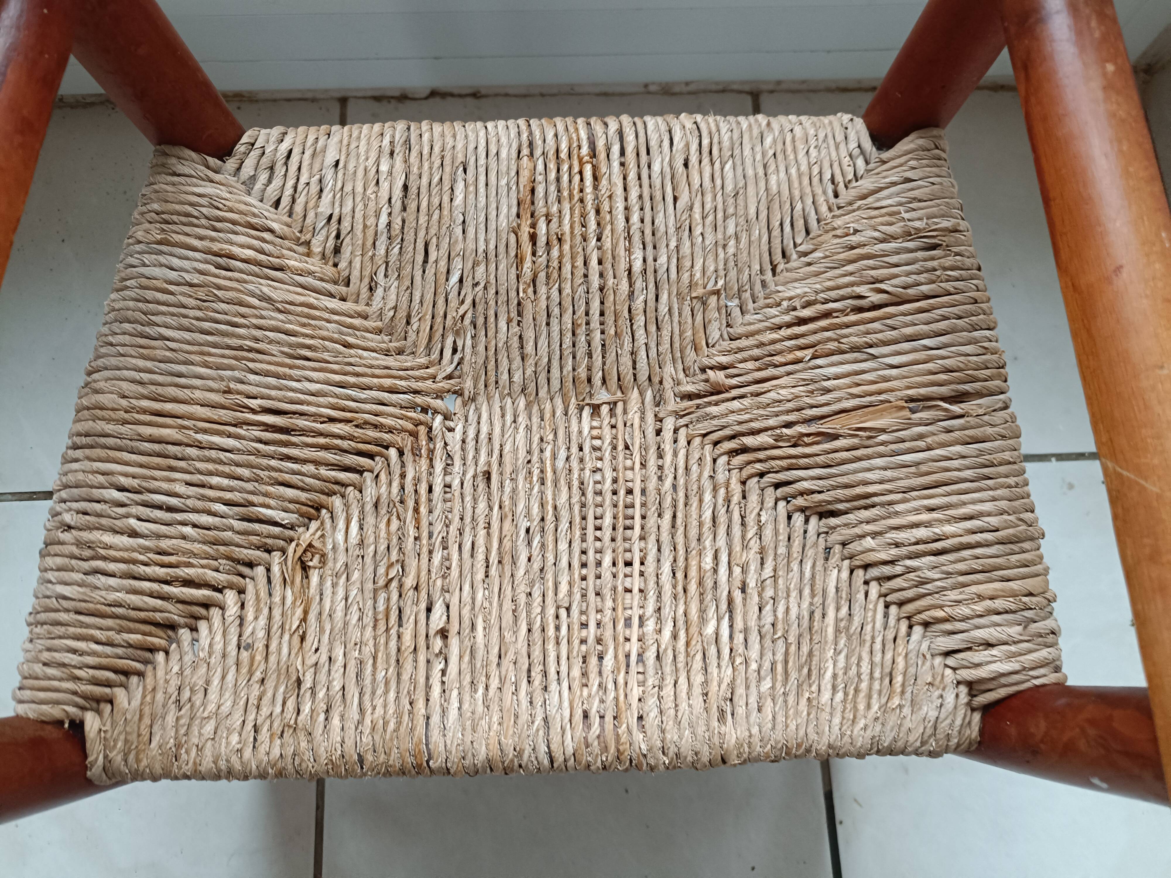 Children's wooden armchair and straw-covered seat.