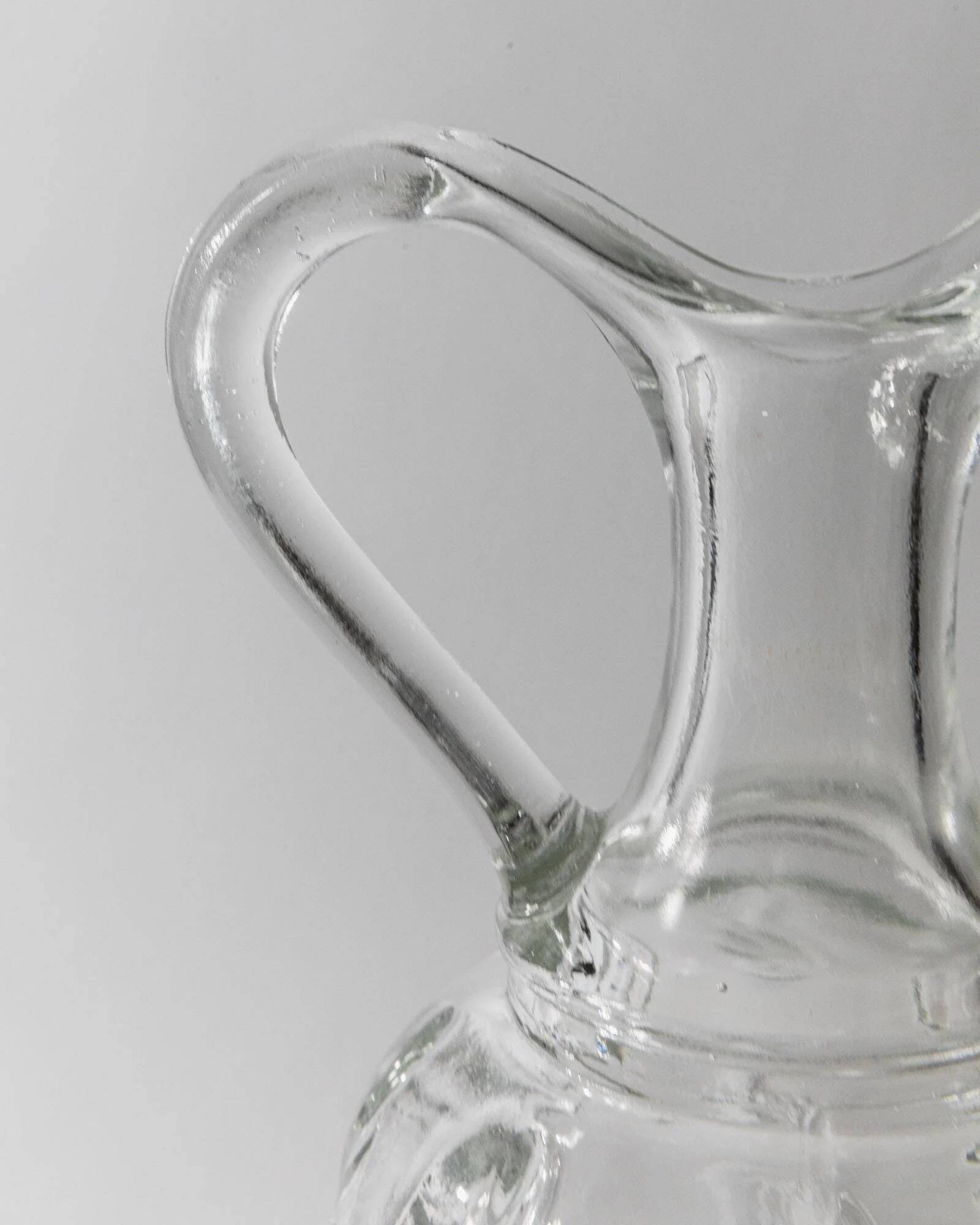 Vintage pressed glass carafe from the 1960s, clear sculptural glass with textured patterns and a stopper.