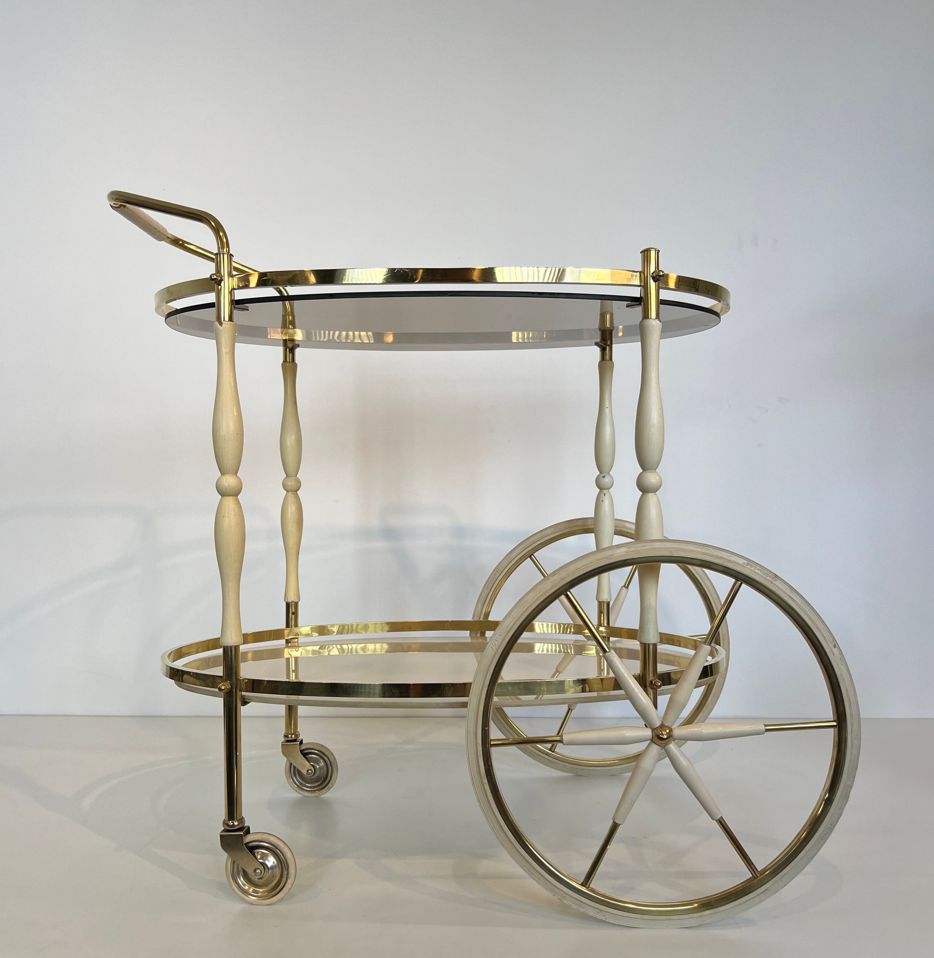 Italian oval rolling table in brass and lacquered wood.