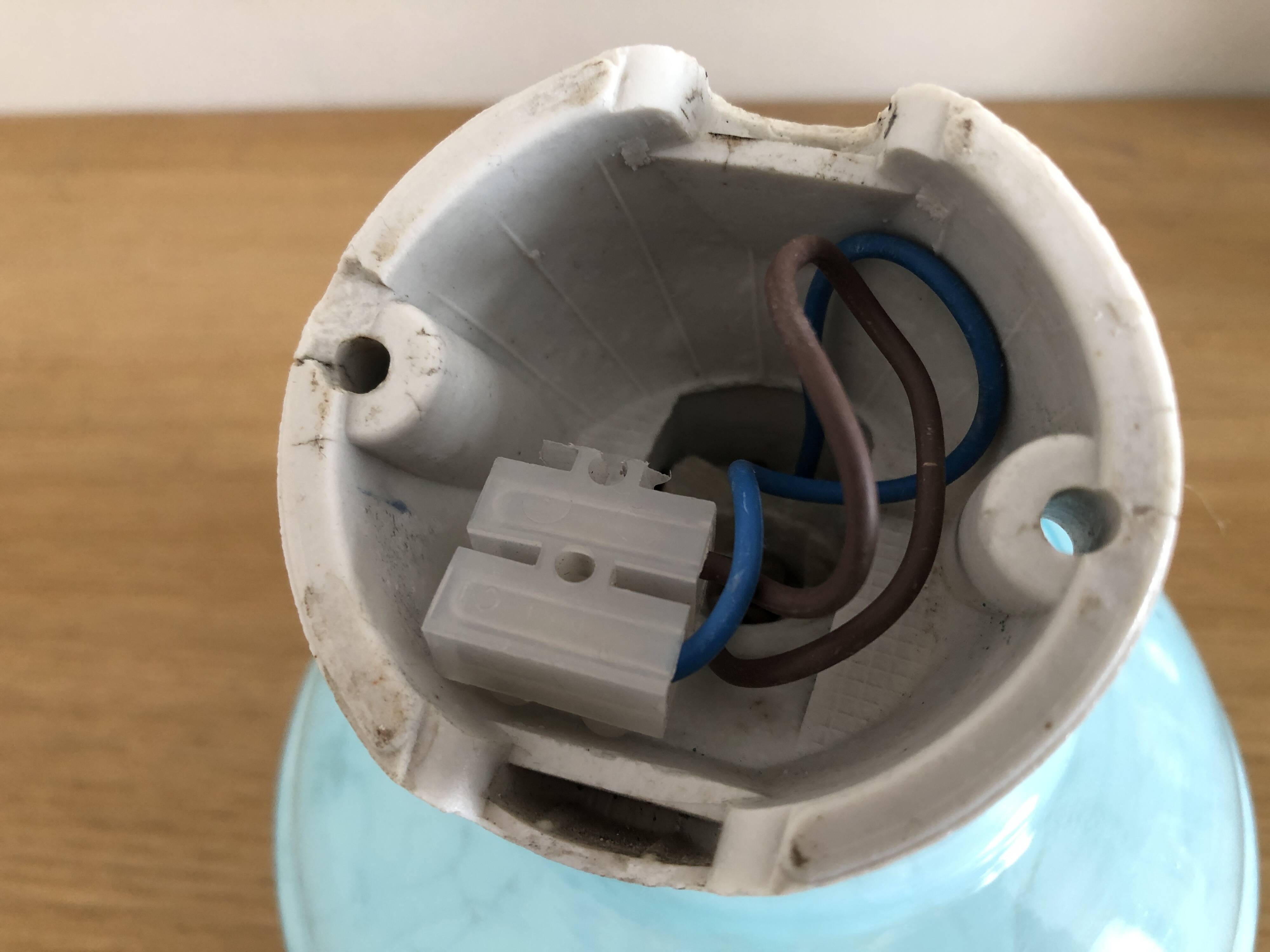 Wall light in ceramic with a light blue glass globe.