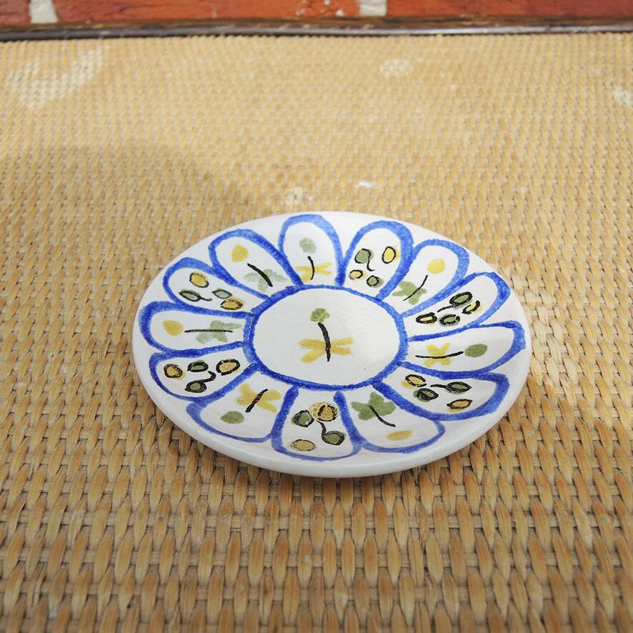 Old ceramic saucer decorated with hand-painted flowers.