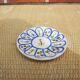 Old ceramic saucer decorated with hand-painted flowers.