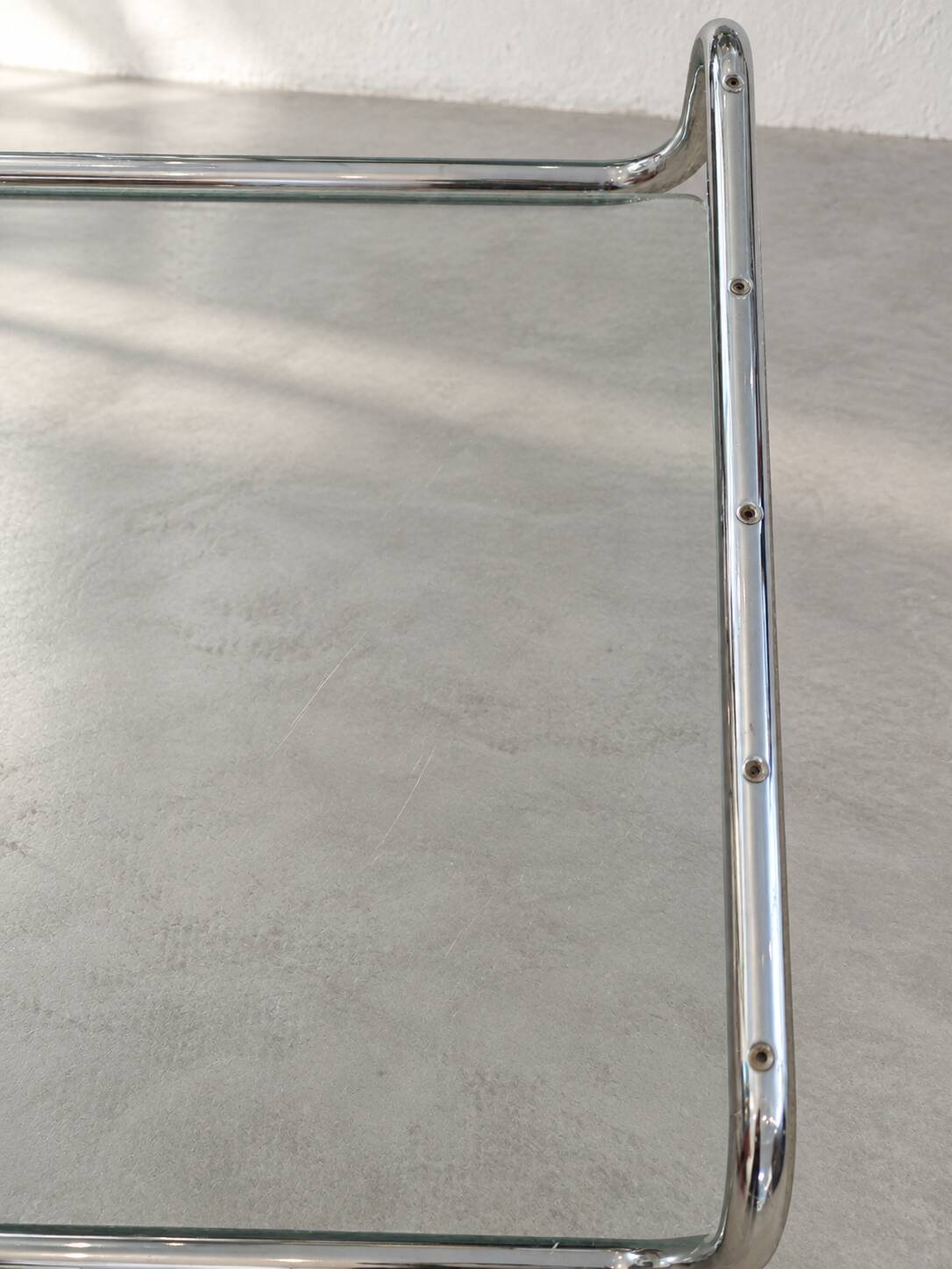 Coffee table in chrome with a glass top.