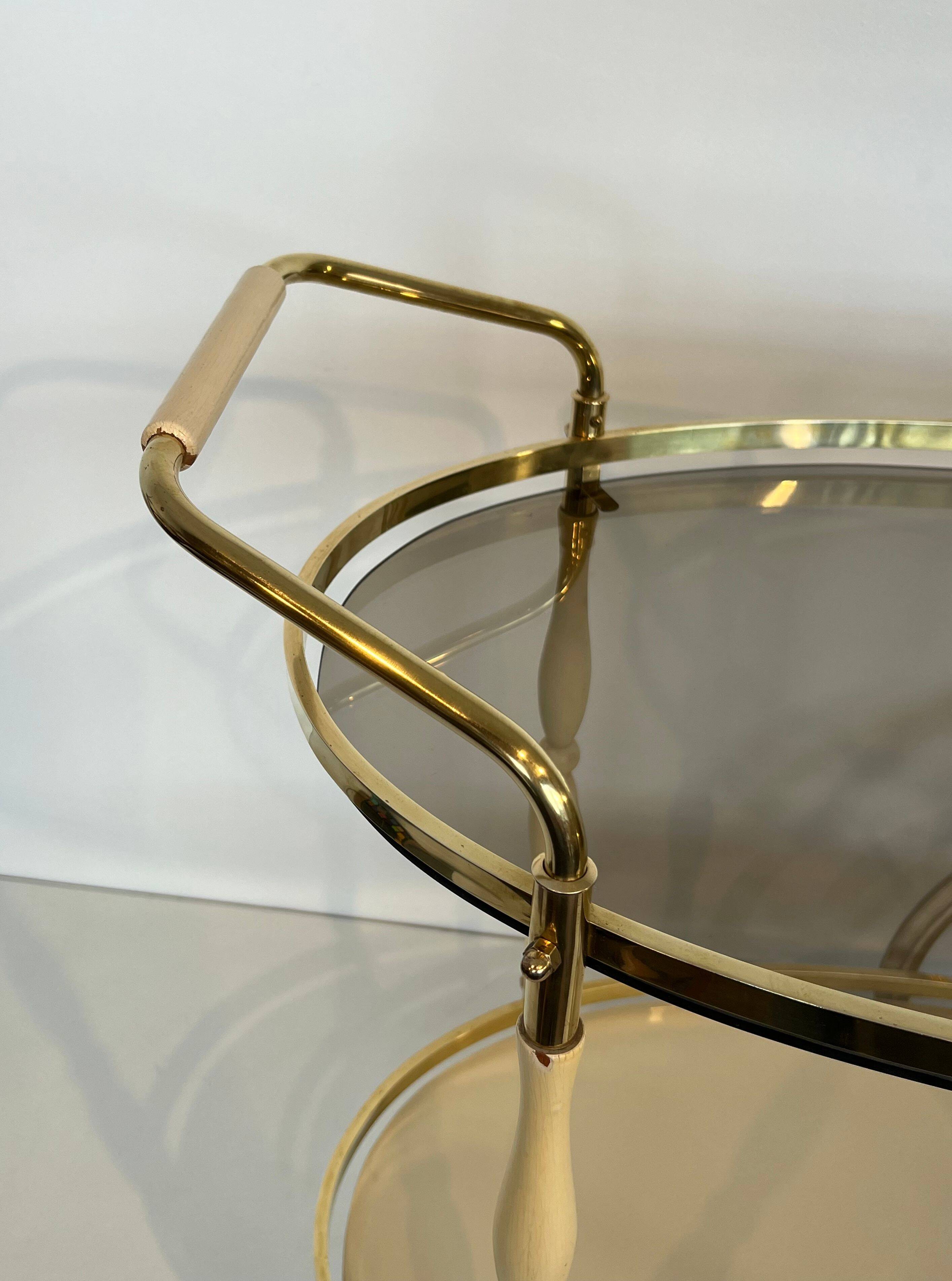 Italian oval rolling table in brass and lacquered wood.