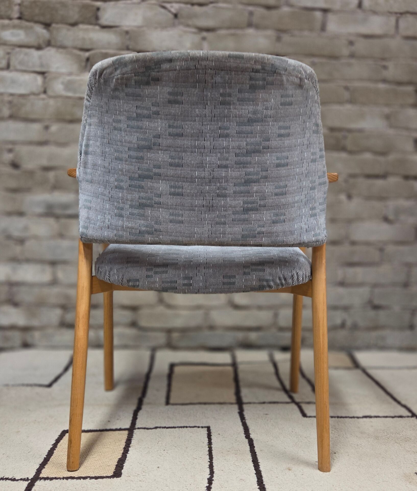 Vintage armchair from the 60s/70s in wood and grey fabric – with armrests.