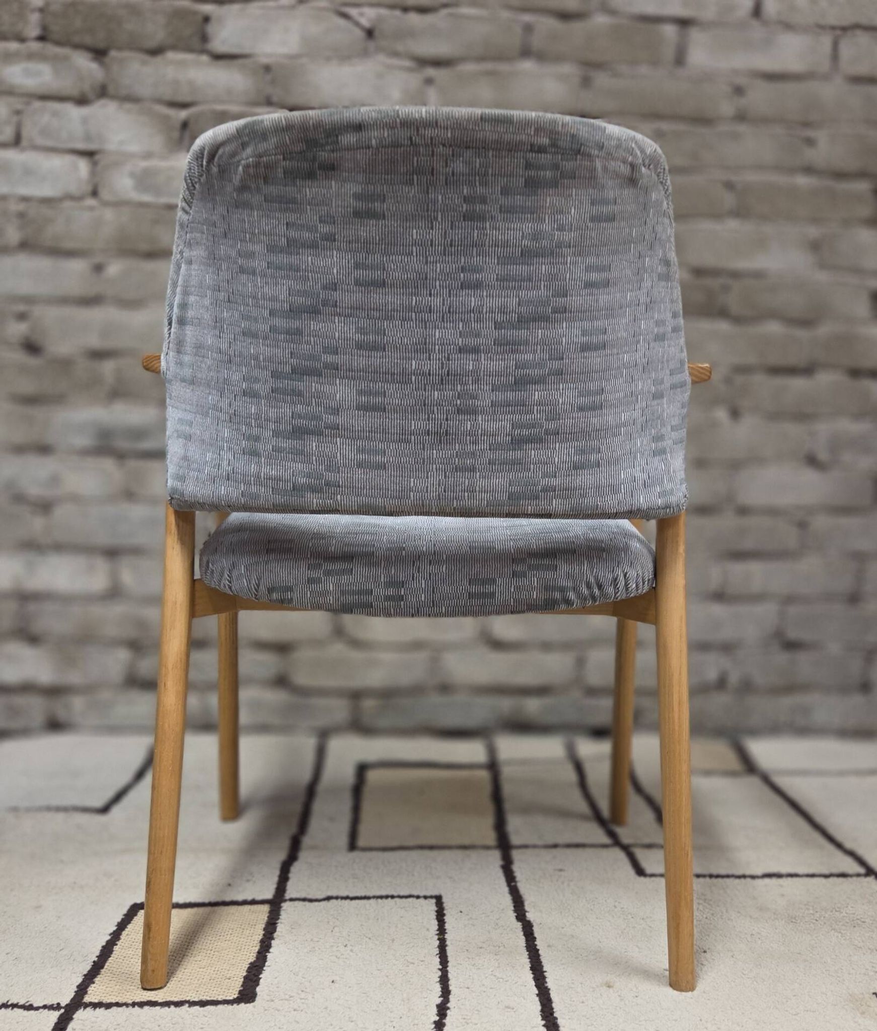 Vintage armchair from the 60s/70s in wood and grey fabric – with armrests.