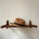 Wall-mounted coat rack made of turned wood in a bamboo style.