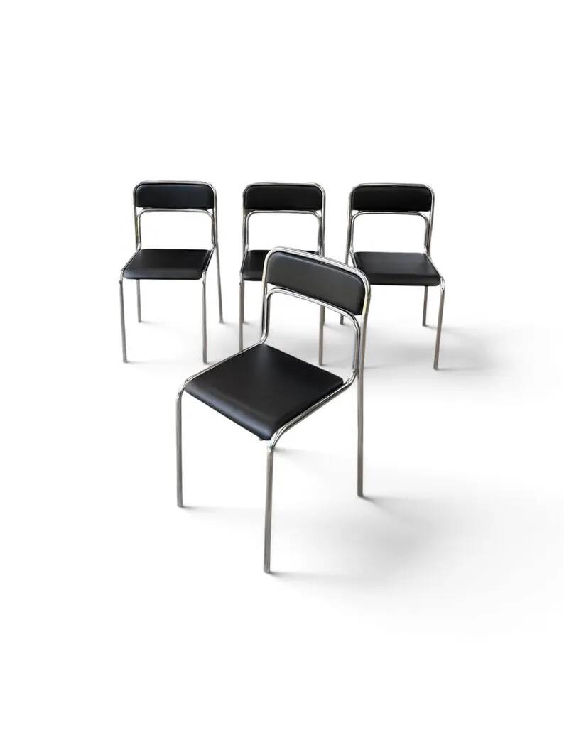 Bauhaus-style tubular steel chairs with black faux leather upholstery, Italian modernist dining room