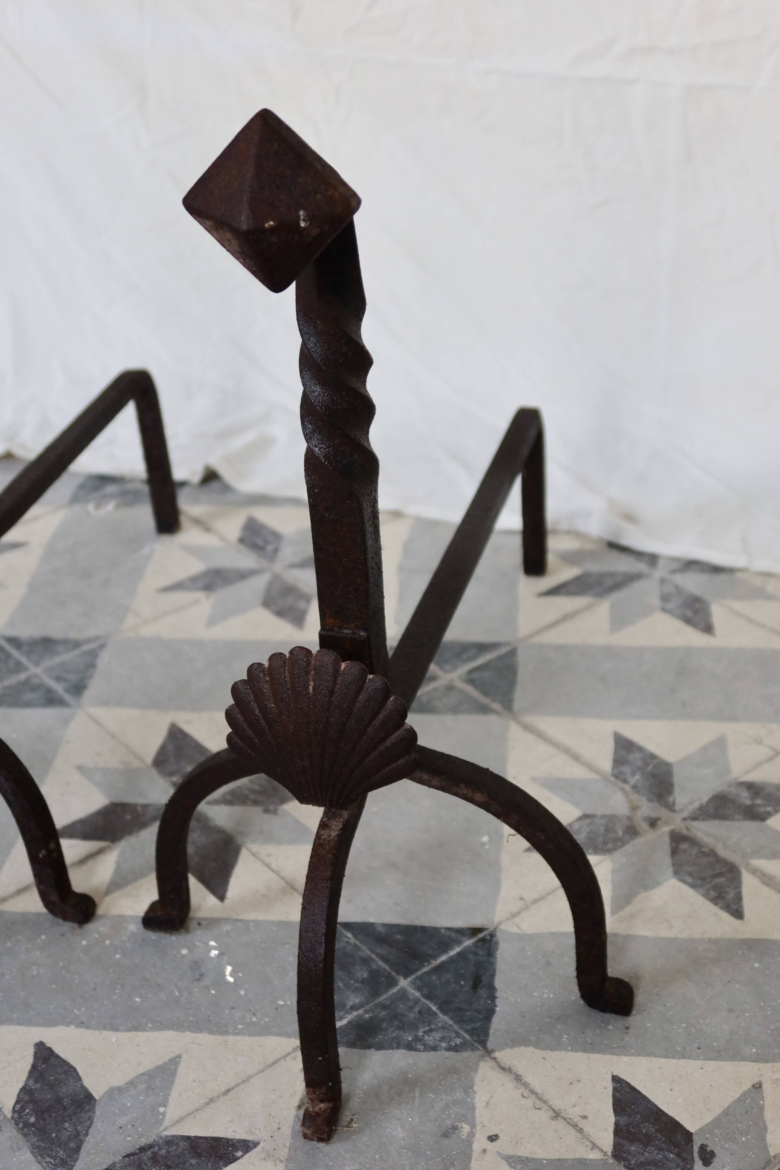 Vintage metal and cast iron fire dogs with shell motif.