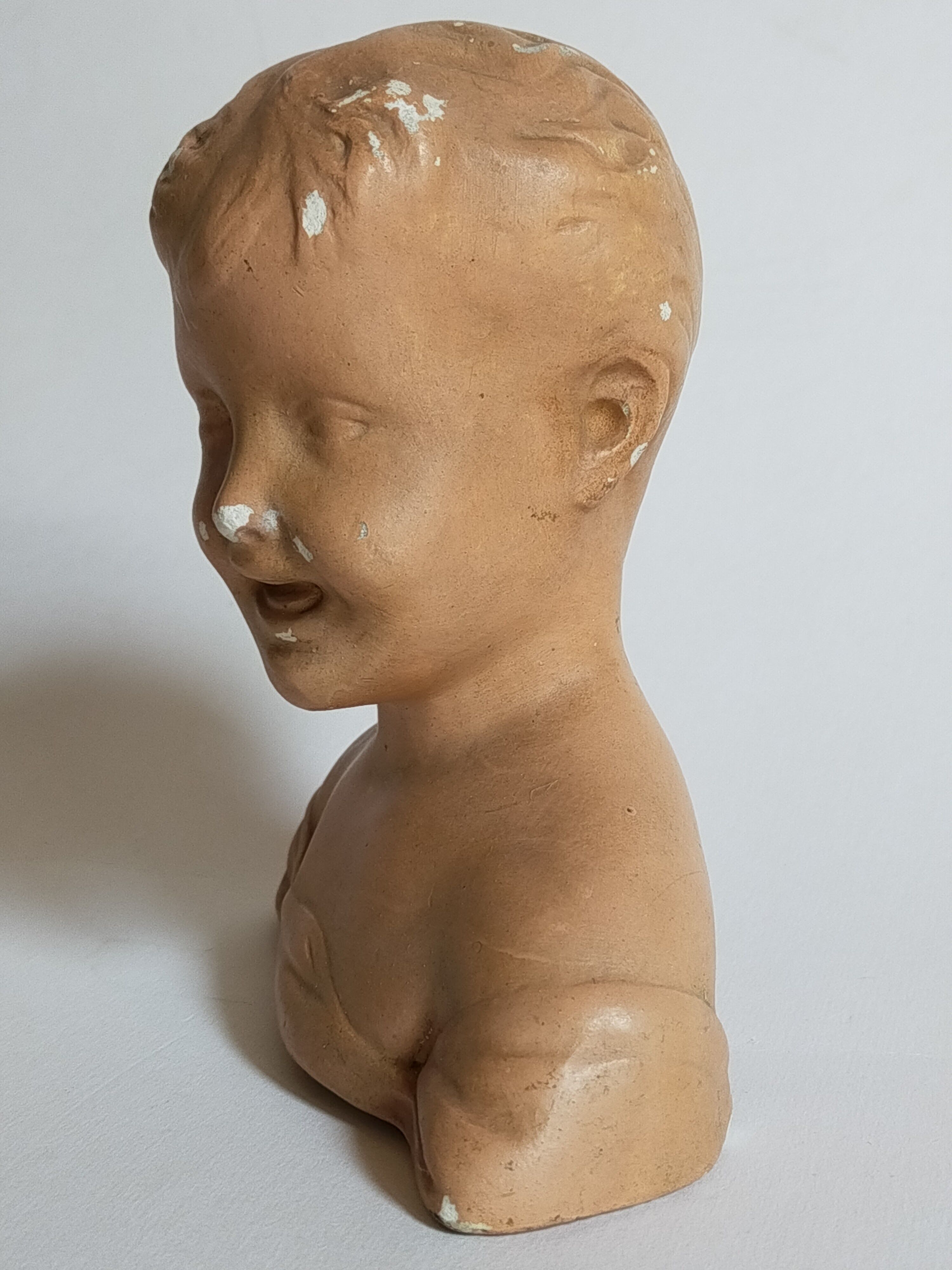 Bust of a small child in ancient plaster