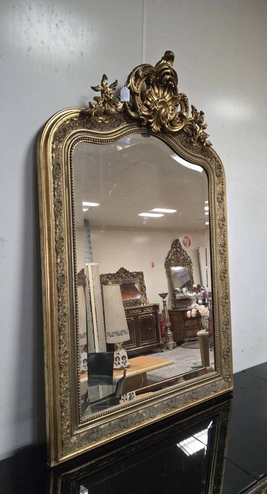 Large carved and gilded wooden mirror, rectangular in shape.
