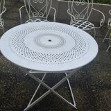 Folding round table and four wrought iron armchairs
