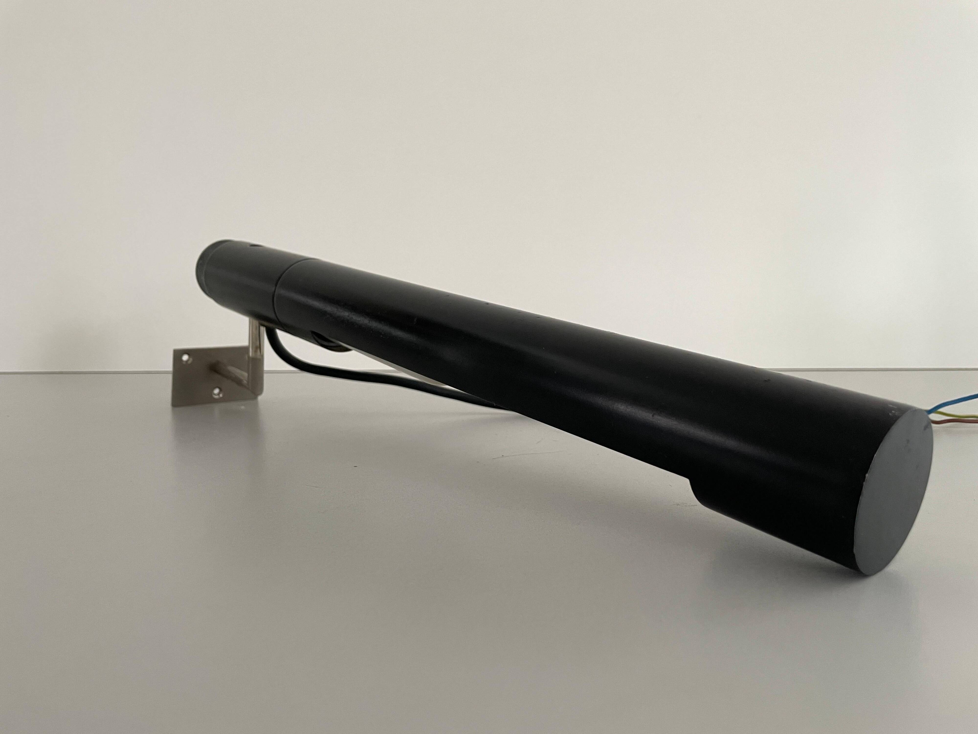 Minimalist black metal wall light with a cylindrical design, 1960s, Germany.