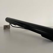 Minimalist black metal wall light with a cylindrical design, 1960s, Germany.