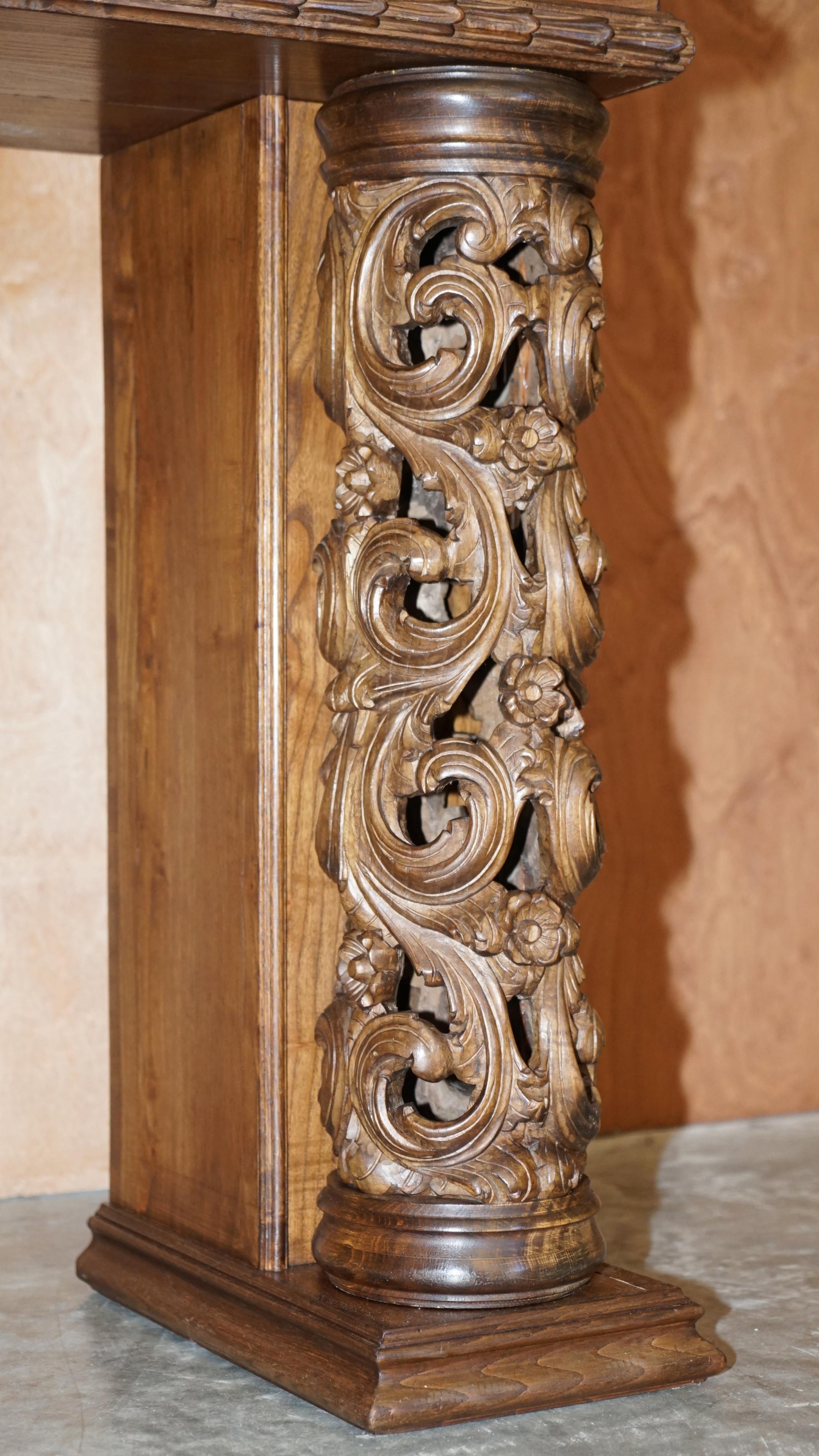 Antique fireplace from around 1880 in solid hand-carved elm with openwork columns.