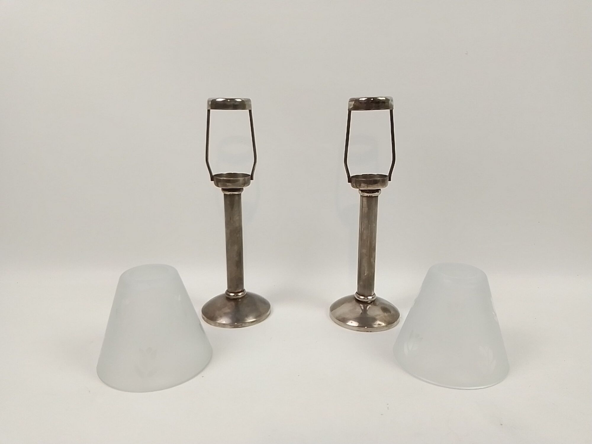 Pair of metal candlesticks with glass lampshade