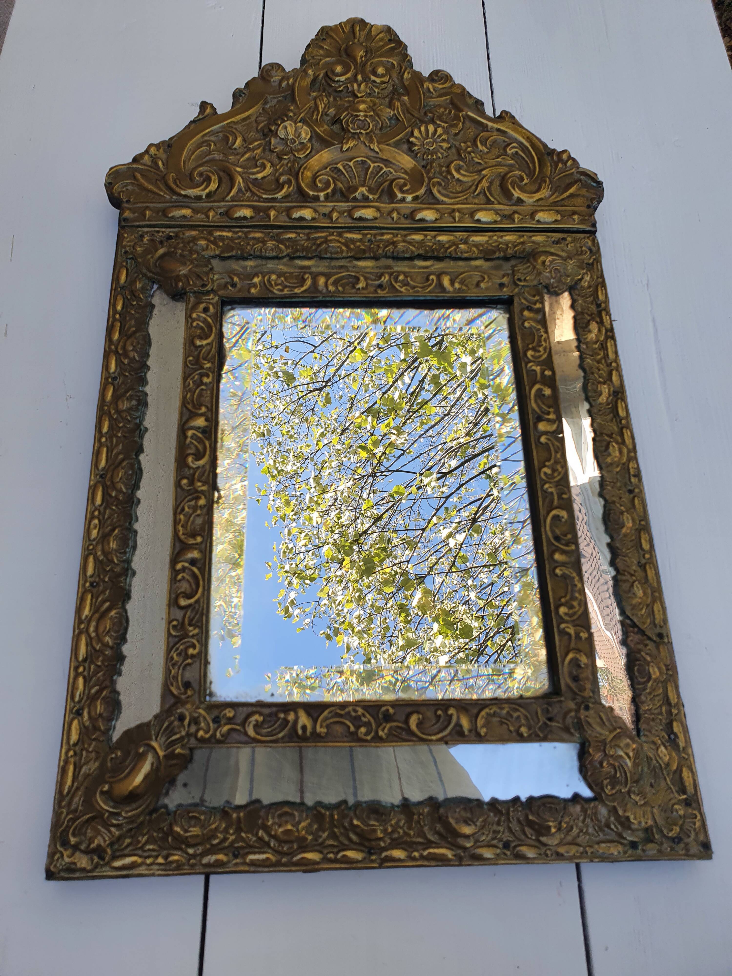 Miroir à parecloses en bois doré et métal repoussé