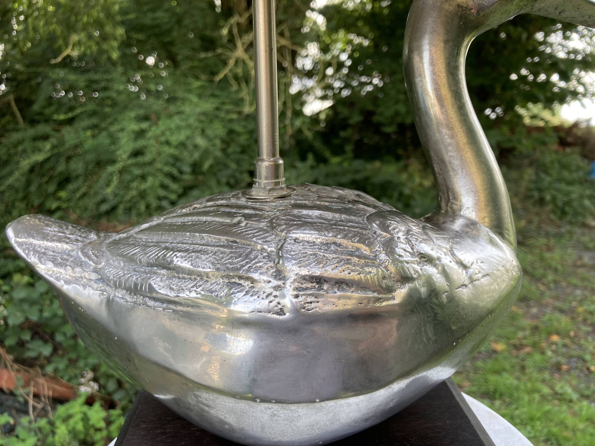 Old vintage lamp representing a duck in silver metal with wooden base