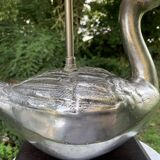 Old vintage lamp representing a duck in silver metal with wooden base