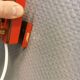 Danish red lacquered wall light with brass details. Estimated 1980s