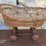 Old rattan cradle on wheels