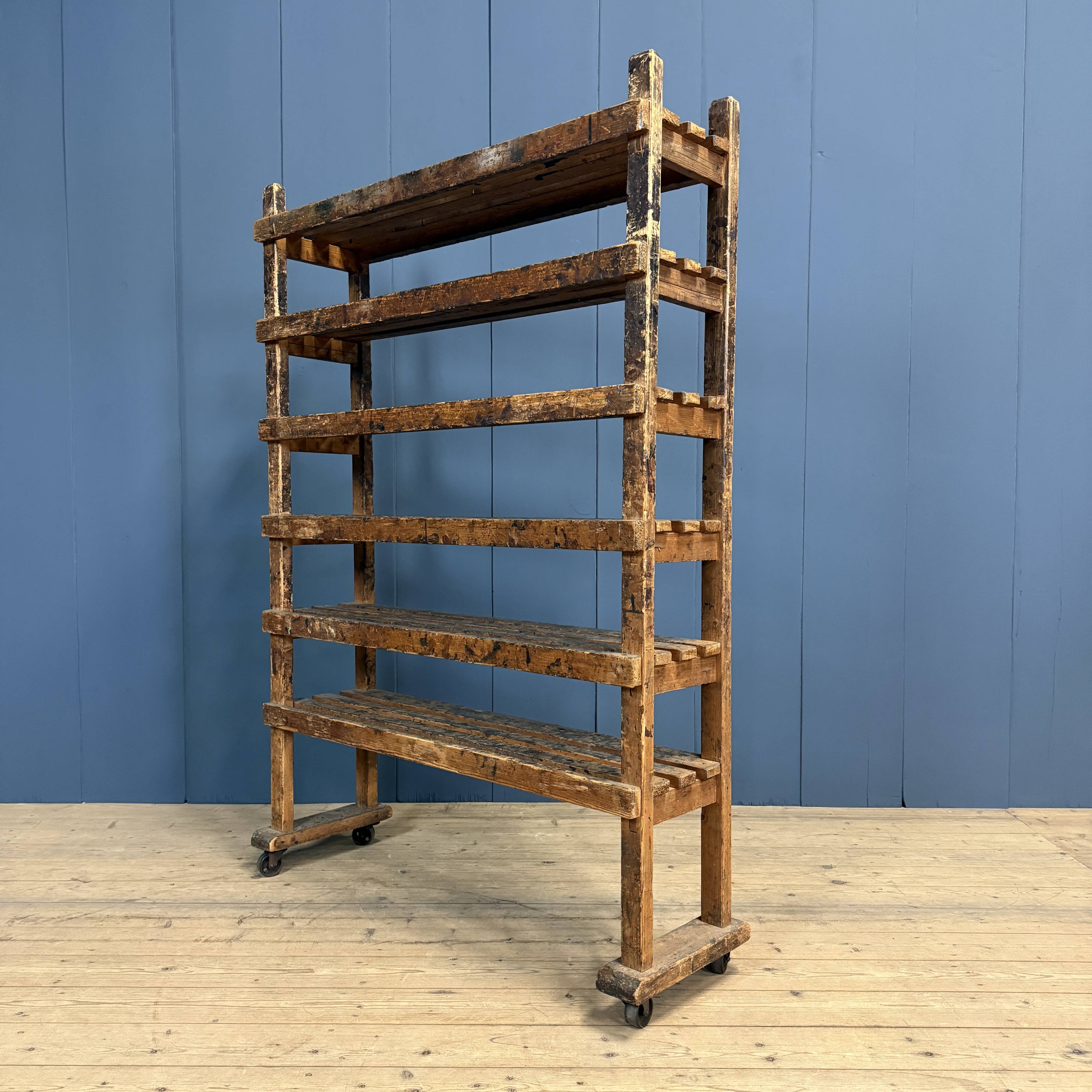 Old wooden workshop shelf with cast iron wheels.